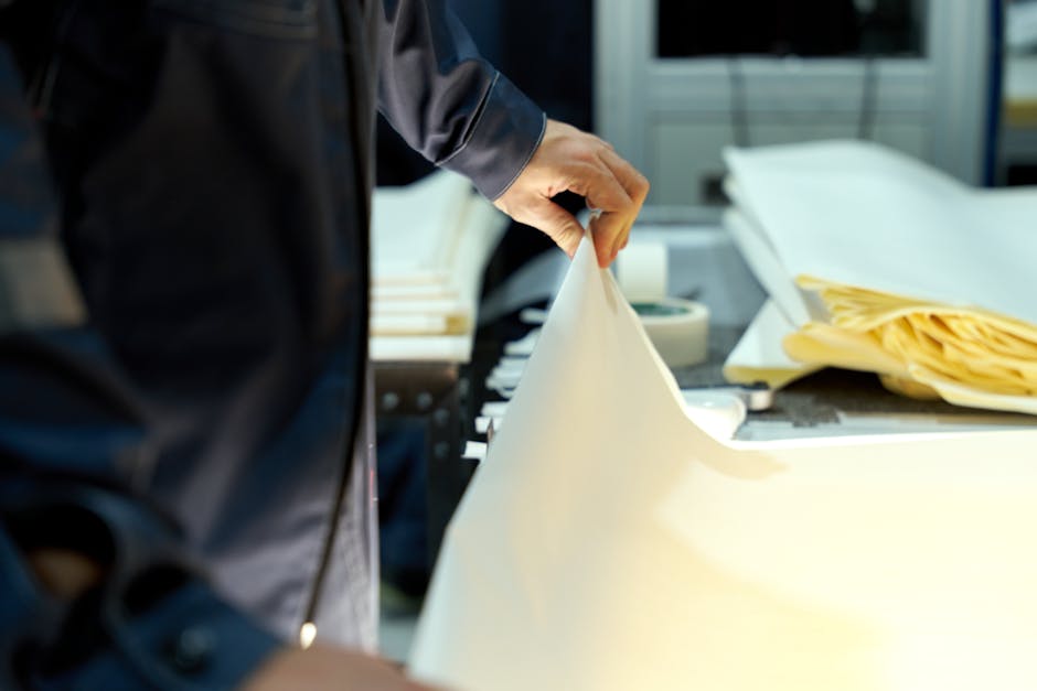 An industrial worker manages large sheets in a manufacturing setting
